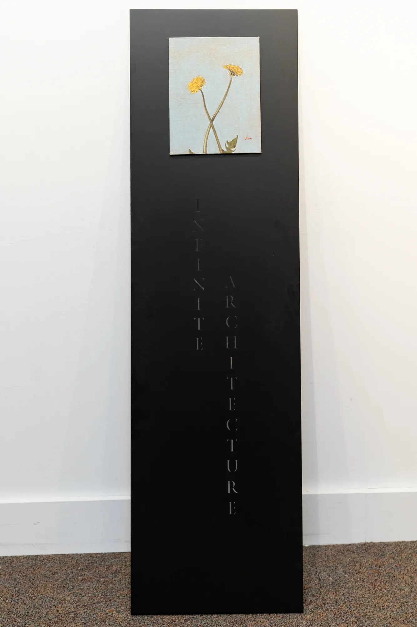 A cluster of flowers against the sky attached to a tall metal plinth