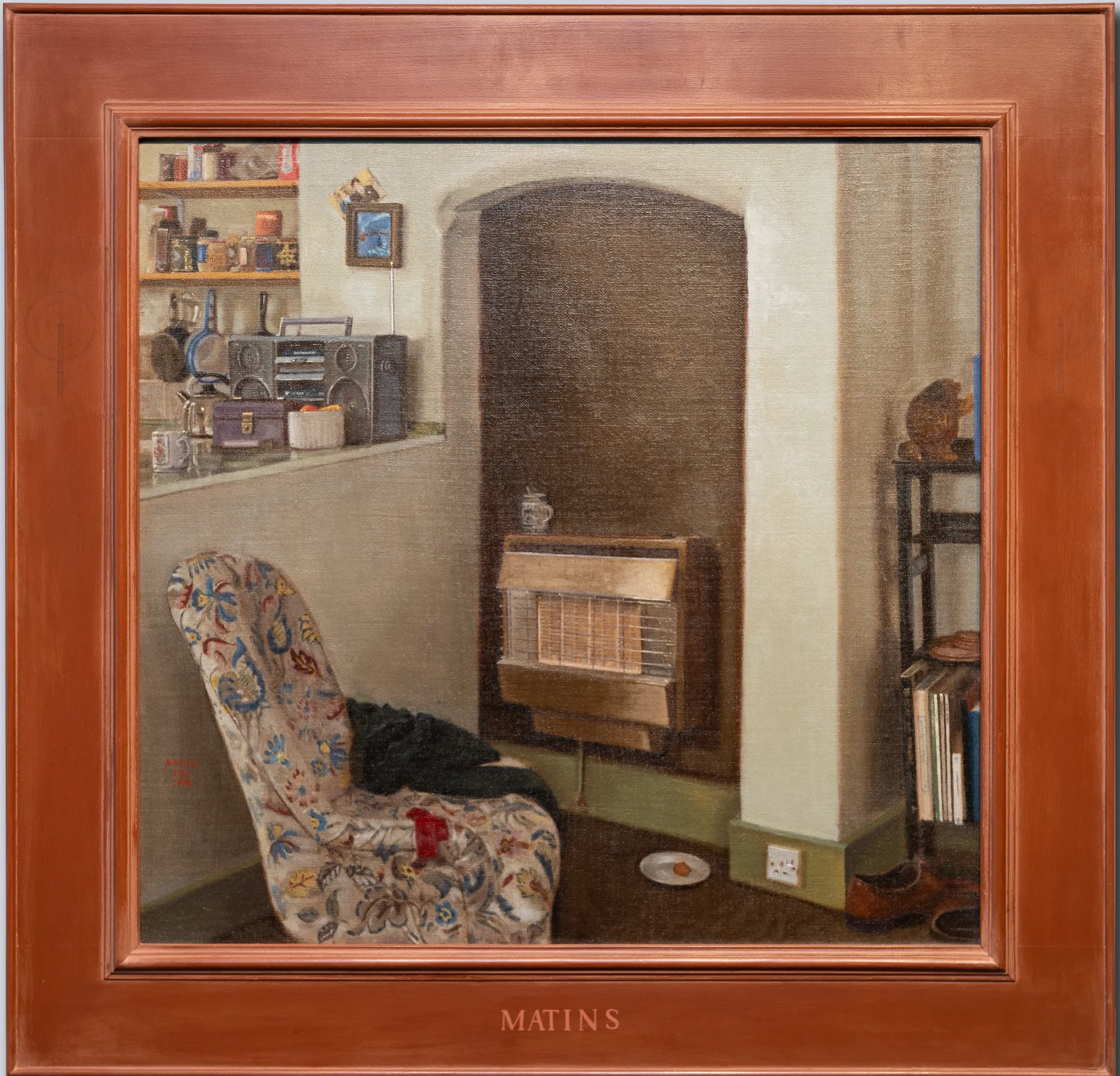 A chair sits by an unlit gas fire, a cup on the floor beside it.