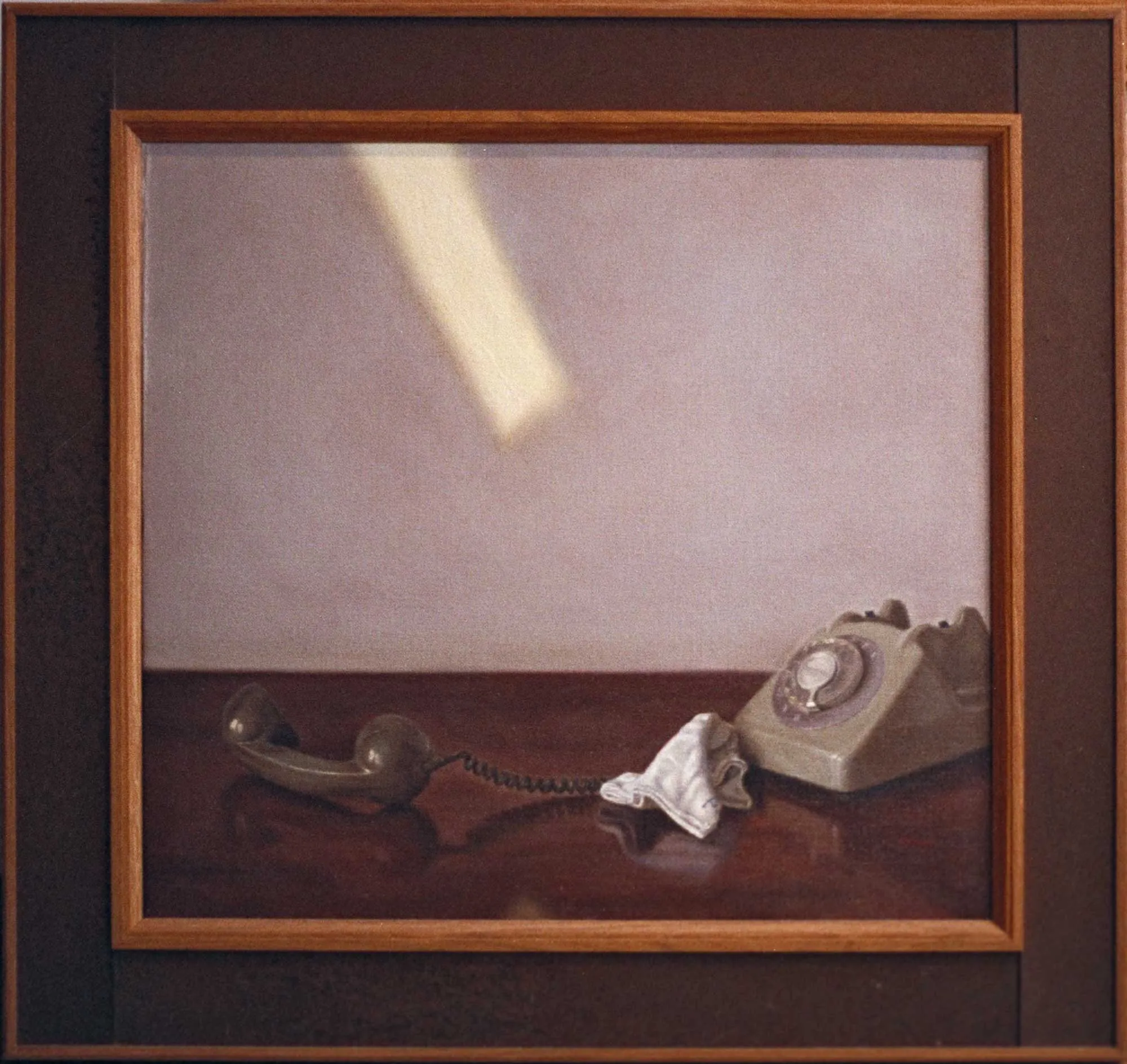 Telephone, receiver off sits on a table with a crumpled handkerchief.